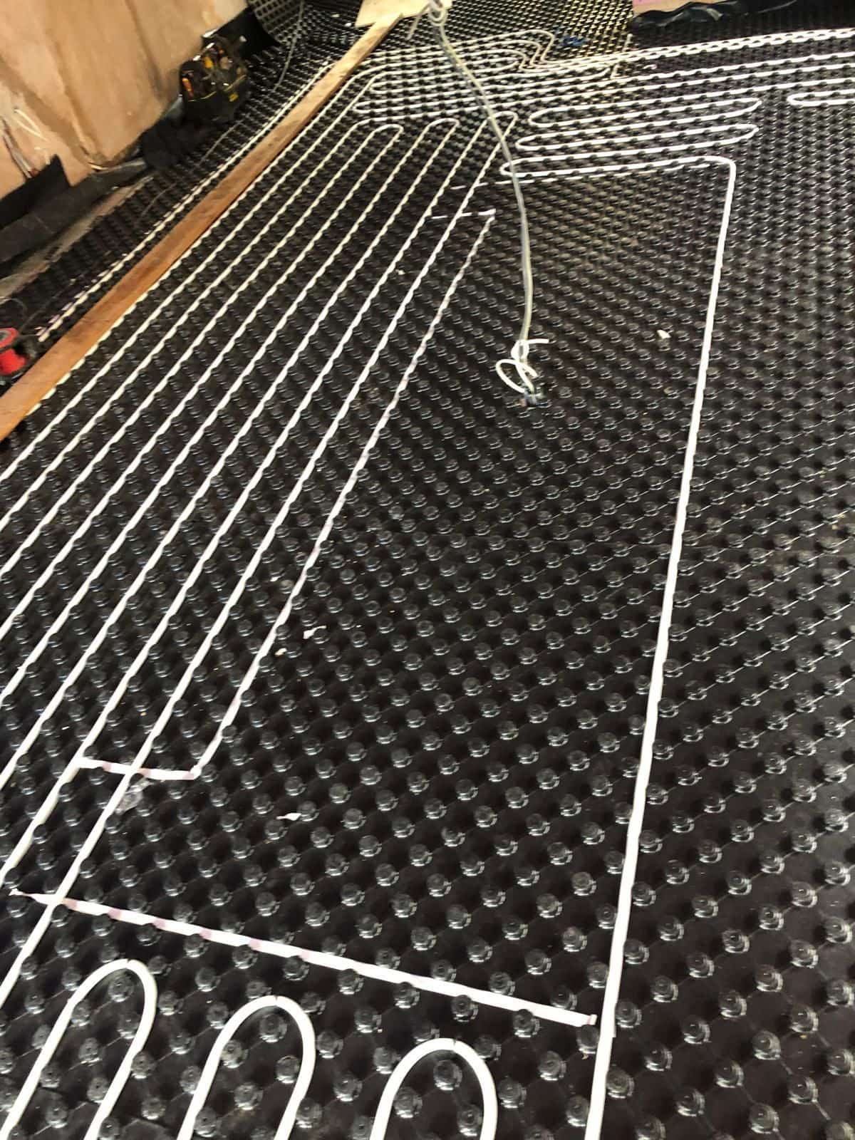 Underfloor heating pipework being laid