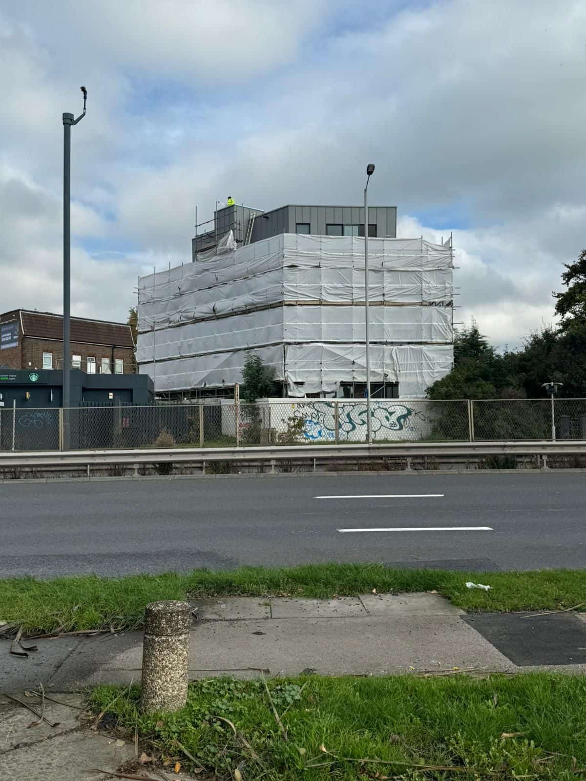 The block taking shape behind its scaffold wrap